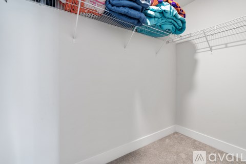 A white wall with clothes hanging on a wire rack.