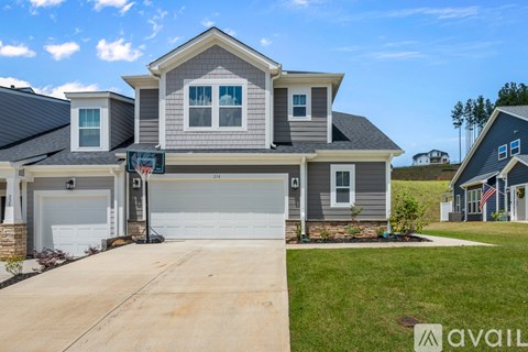 A house with a garage and a driveway in front of it.