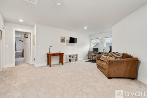 A living room with a brown couch and a wooden table.