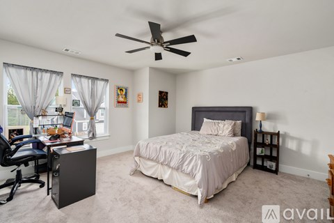 A bedroom with a bed, desk, and chair.