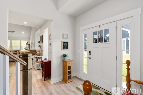 A white interior with a staircase on the left and a doorway on the right.
