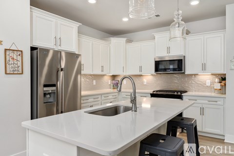 A kitchen with white cabinets and a stainless steel refrigerator.