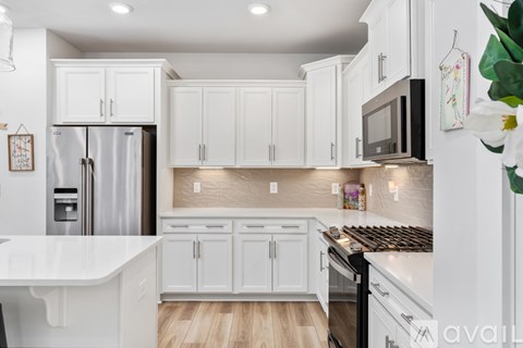 A kitchen with white cabinets and appliances.