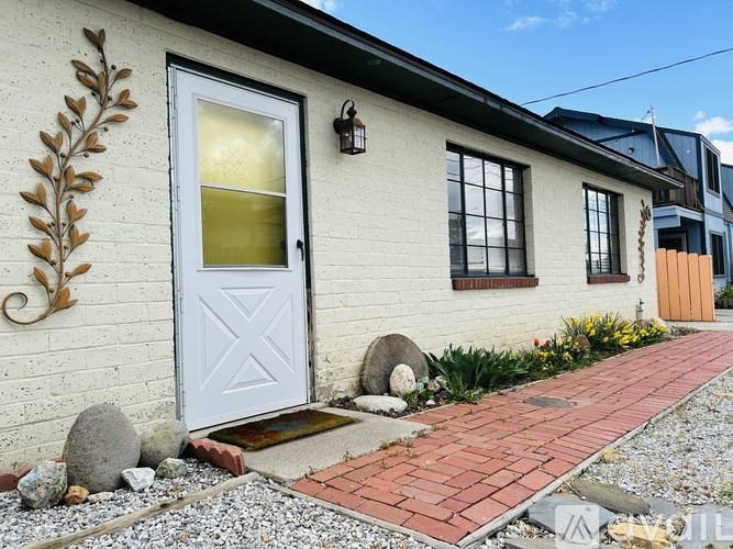 A house with a white door and a grey wall with a leaf design.