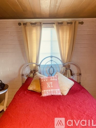 A bed with a pillow that says "You are my sunshine".