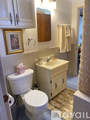 A bathroom with a toilet, sink, and a mirror.