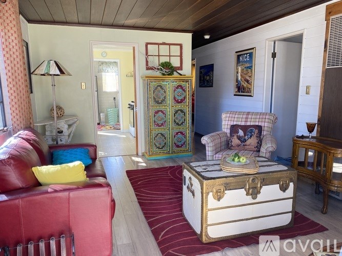 A living room with a red couch and a white trunk.