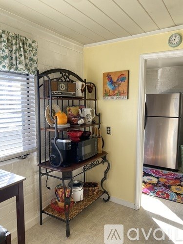 A kitchen with a yellow wall and a clock on it.