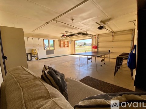 A spacious garage with a couch and a table in the foreground.