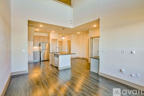 A spacious kitchen with white cabinets and a wooden floor.
