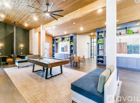 A spacious living room with a billiard table and comfortable seating.