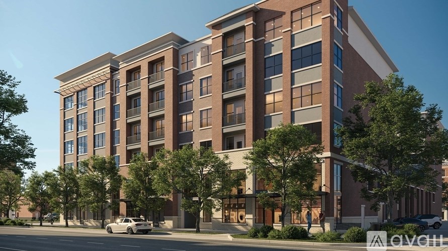 A modern apartment building with a car parked in front.