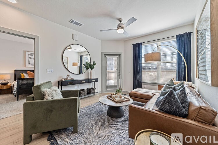 A living room with a green couch, a coffee table, and a mirror on the wall.