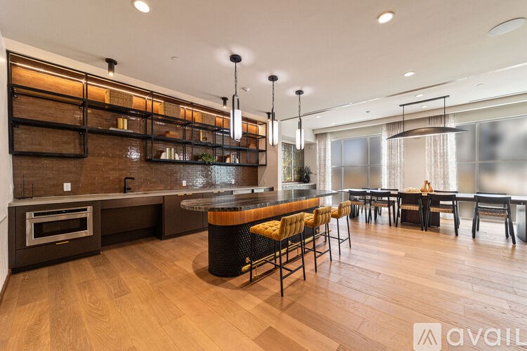 A modern kitchen with a wooden floor and a large island in the center.
