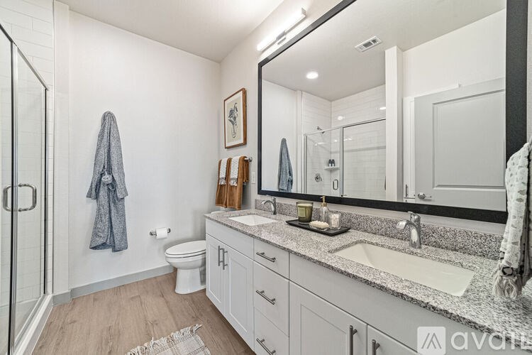A bathroom with a toilet, sink, and mirror.