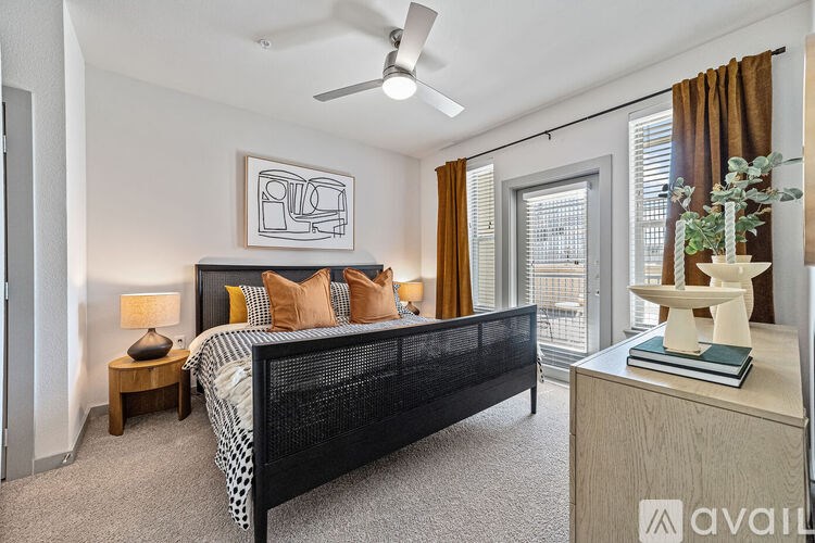 A bedroom with a black bed and a ceiling fan.
