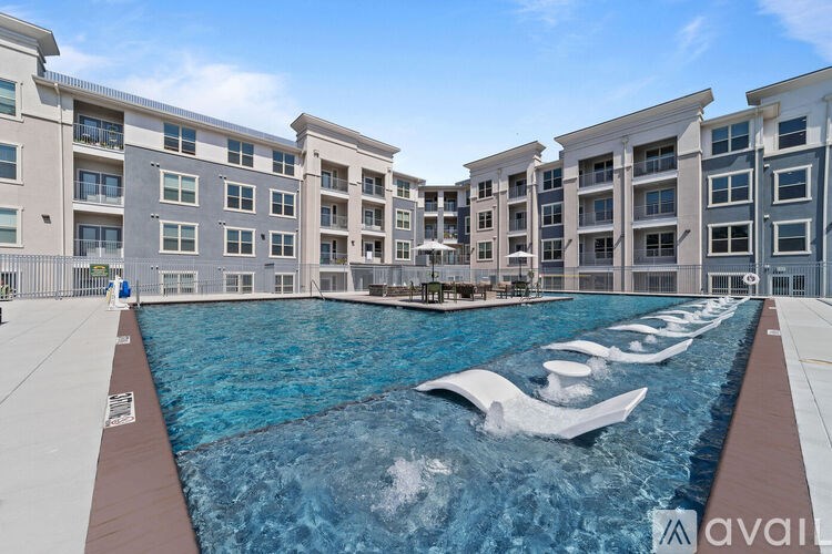 A large pool with a water slide in the middle of a residential area.