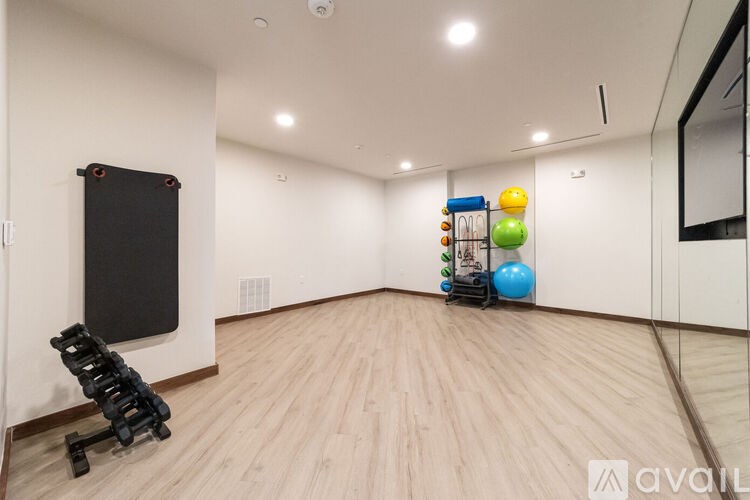 A room with wooden flooring and a black screen on the wall.
