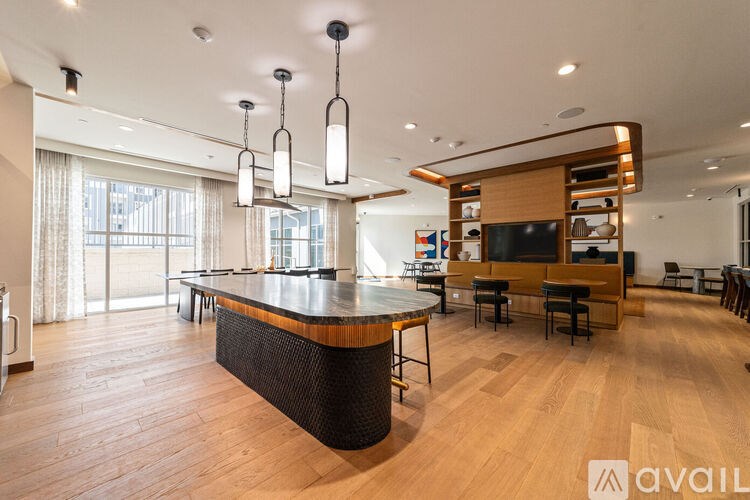 A modern kitchen with a wooden island and pendant lights.