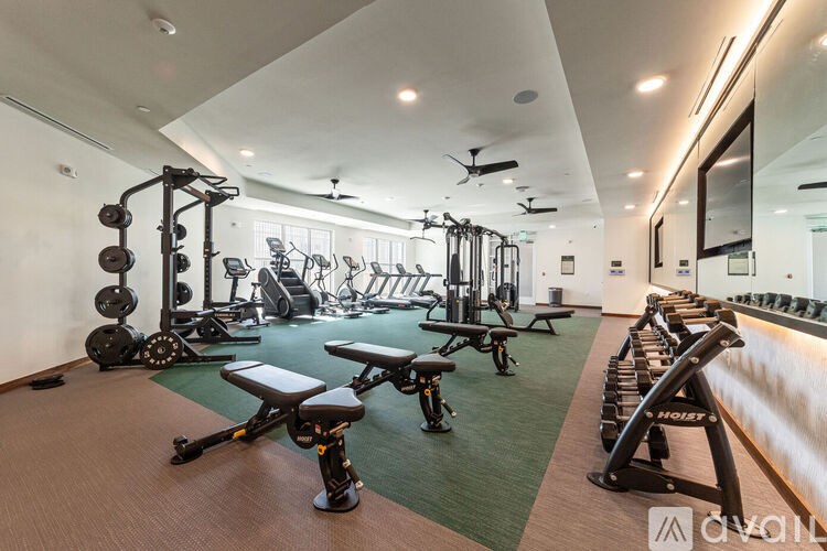 A gym with a variety of equipment including weights and machines.