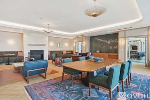 A living room with a blue rug and a wooden table.