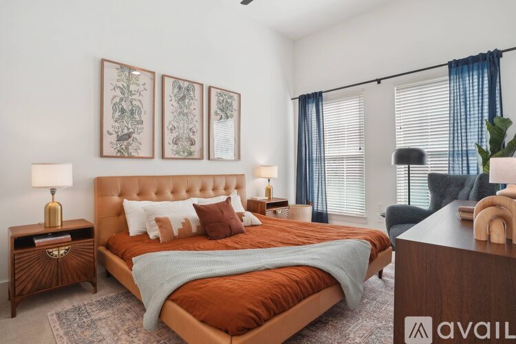 A bedroom with a large bed, a nightstand with a lamp, and a chair.