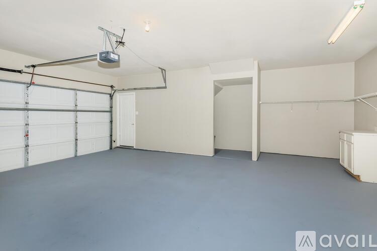 A spacious garage with a white door and a grey floor.