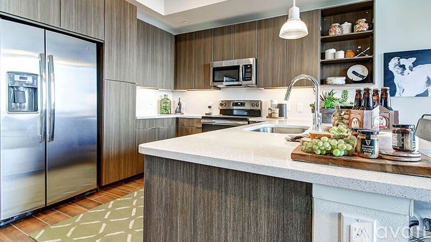 A kitchen with a white counter top and a refrigerator.