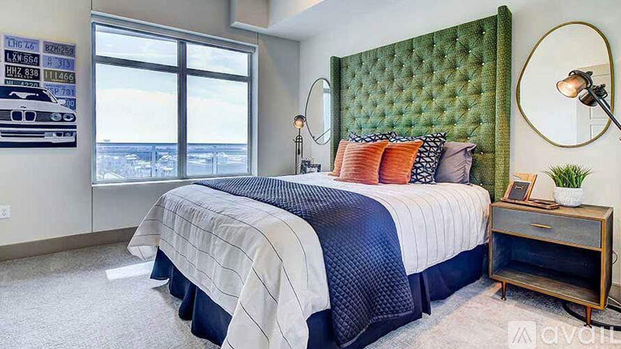 A bedroom with a large bed and a green headboard.