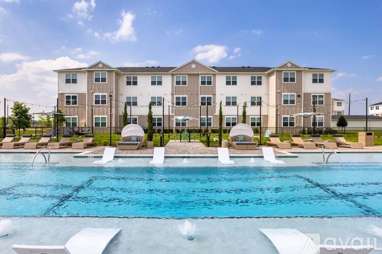 A large apartment complex with a pool in front.