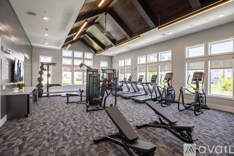 A gym with a variety of equipment including treadmills, weights, and exercise bikes.
