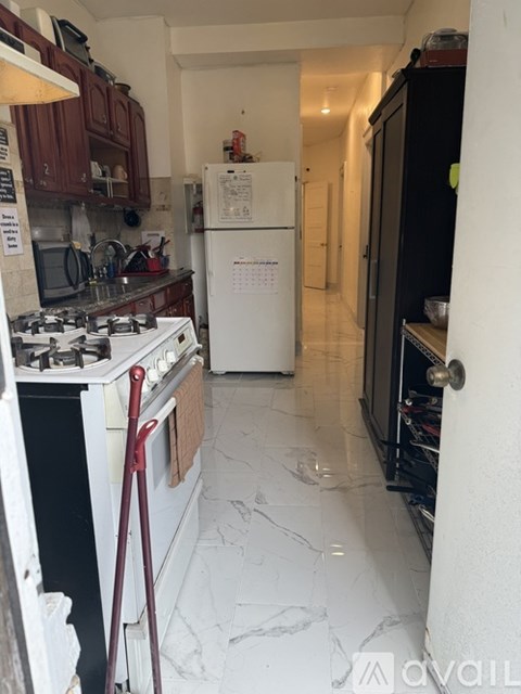 A kitchen with a white stove top oven and a white fridge.