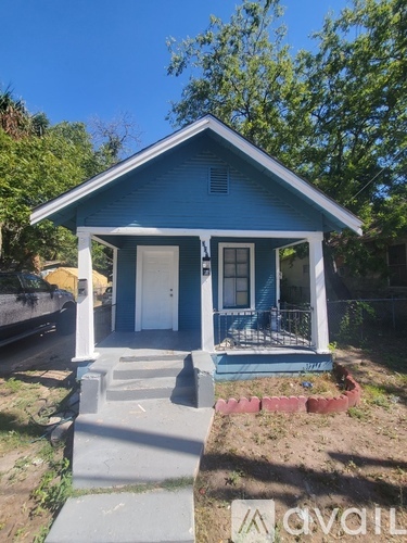A small blue house with a porch and a white door.