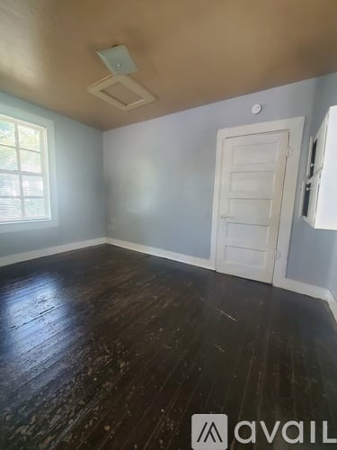 A room with a wooden floor and a white door.