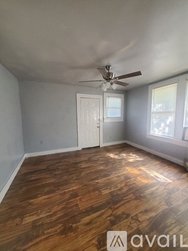 A room with wooden flooring and a ceiling fan.