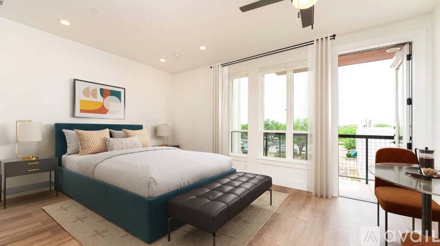 A bedroom with a large bed and a balcony.