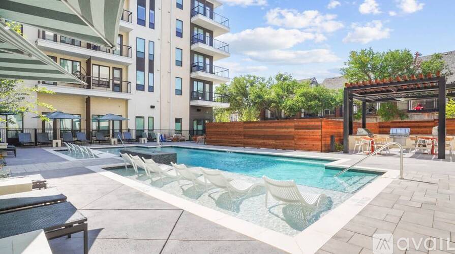 A large outdoor swimming pool with lounge chairs and a pergola.