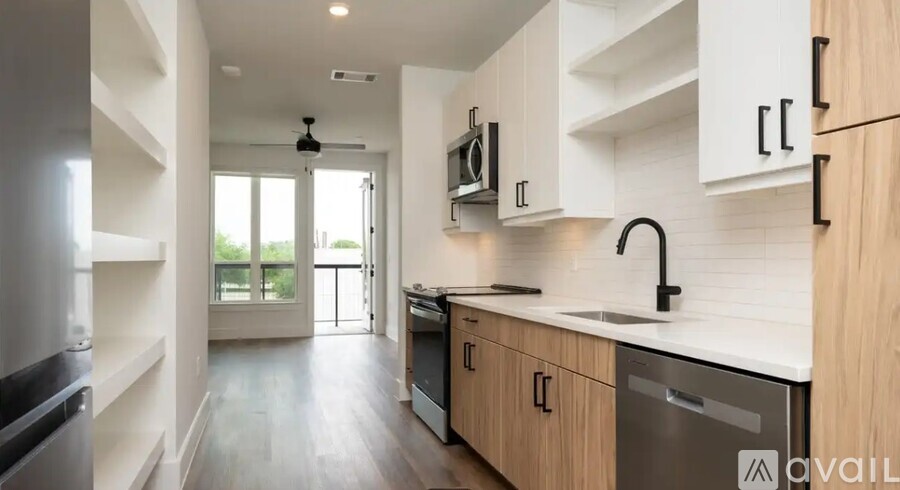 A modern kitchen with wooden cabinets and a black dishwasher.