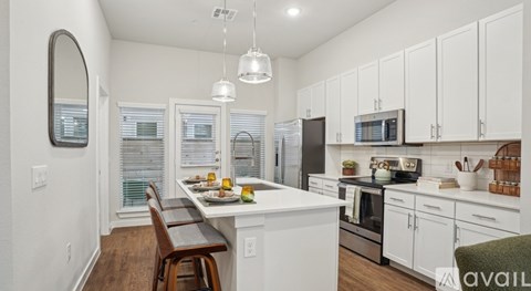 A kitchen with white cabinets and a wooden table.