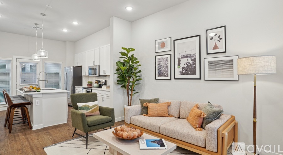 A living room with a couch, chair, and a potted plant.