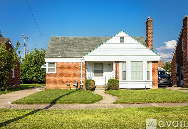 A white house with a brick chimney is for sale.