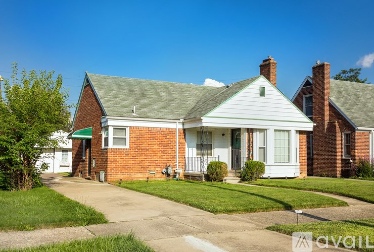 A house with a green lawn and a white front porch.
