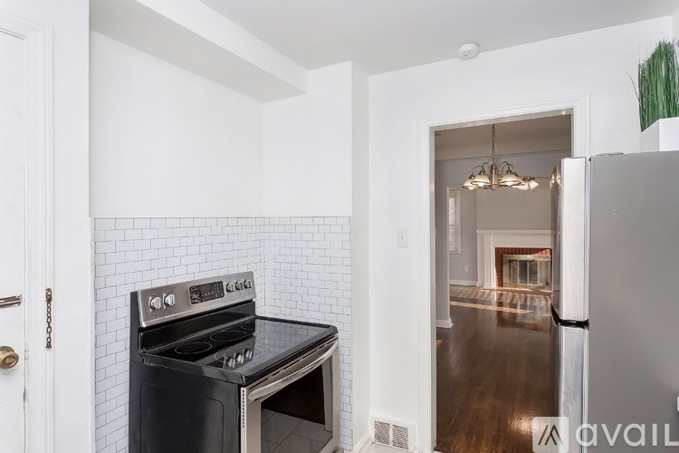 A modern kitchen with a black stove top oven and white tiled backsplash.