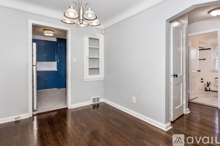 A room with a blue door and a chandelier.