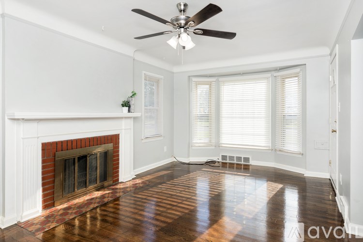 A room with a fireplace and a ceiling fan.