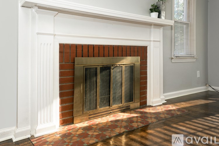 A fireplace with a white mantle and a brick surround.