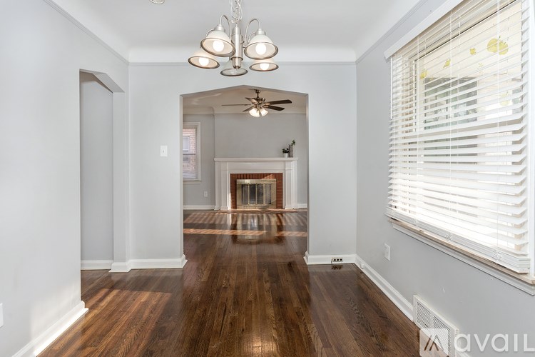 A room with a wooden floor and a chandelier hanging from the ceiling.