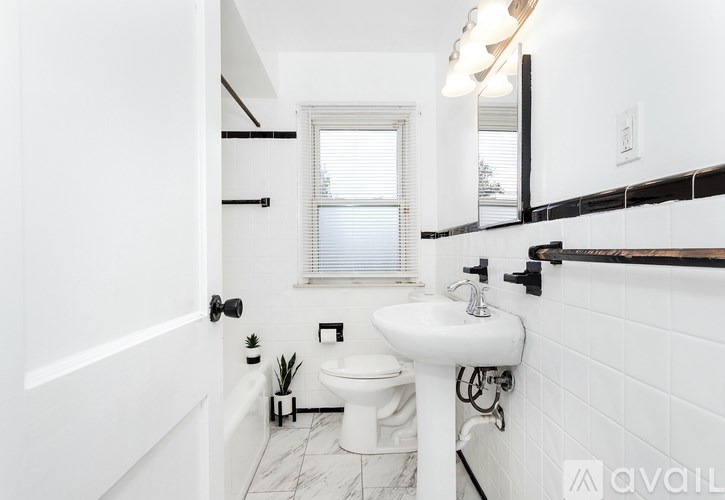 A white bathroom with a toilet, sink, and tub.