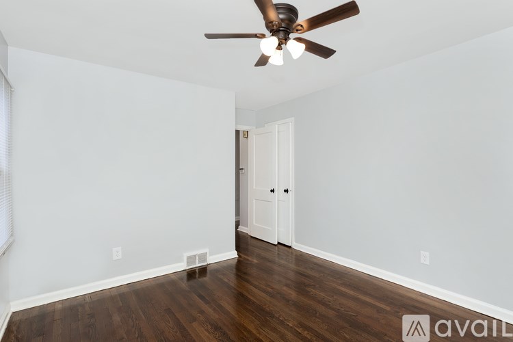 A room with a ceiling fan and wooden floors.