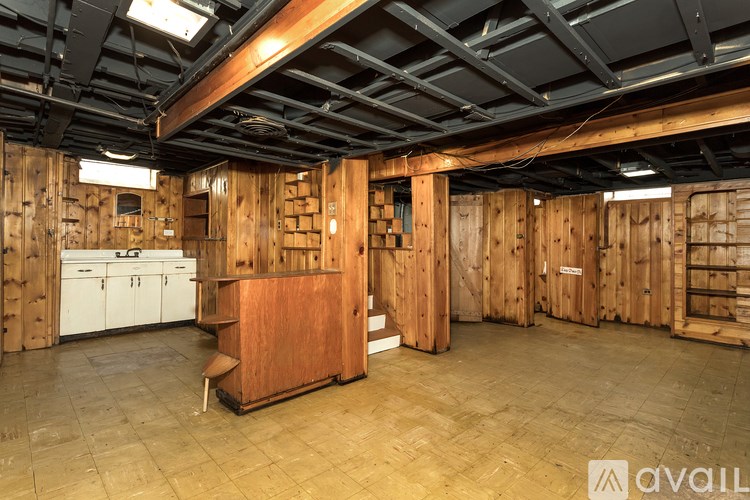 A room with wooden walls and a wooden floor with a wooden cabinet in the middle.